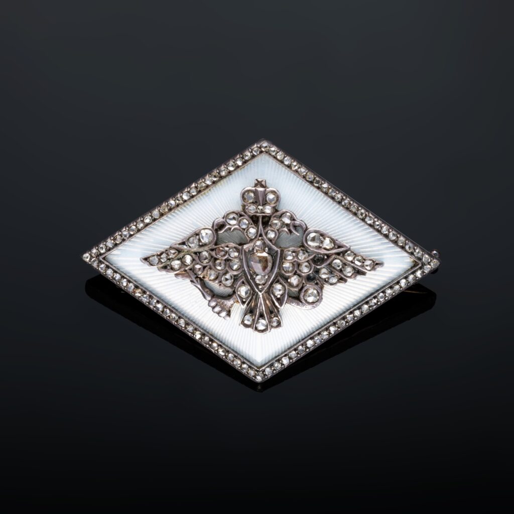 A silver brooch in diamond with white enamelled background with guilloché rays russian by  Fabergé, St. Petersburg, 1896-1908.  H .: 3 cm – L .: 4, 5 cm.